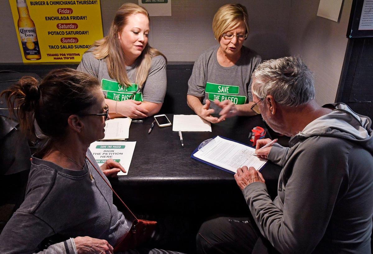 Diane Euston, left, and Helen VanHecke gather signatures at Mama Tio’s in South Kansas City in an effort to undo the renaming of The Paseo for Dr. Martin Luther King Jr.