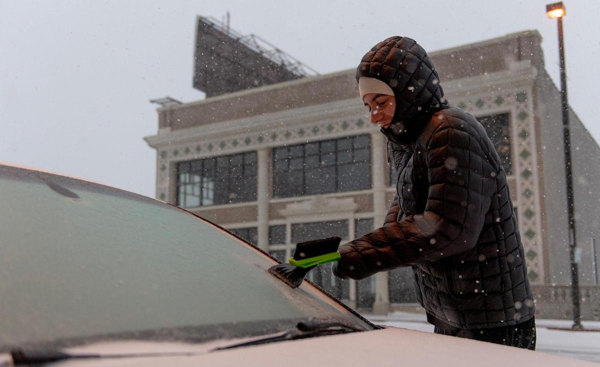Nick Smith clears ice from his windshield as he prepares to drive to work on Thursday, Dec. 22, 2022, in Kansas City.