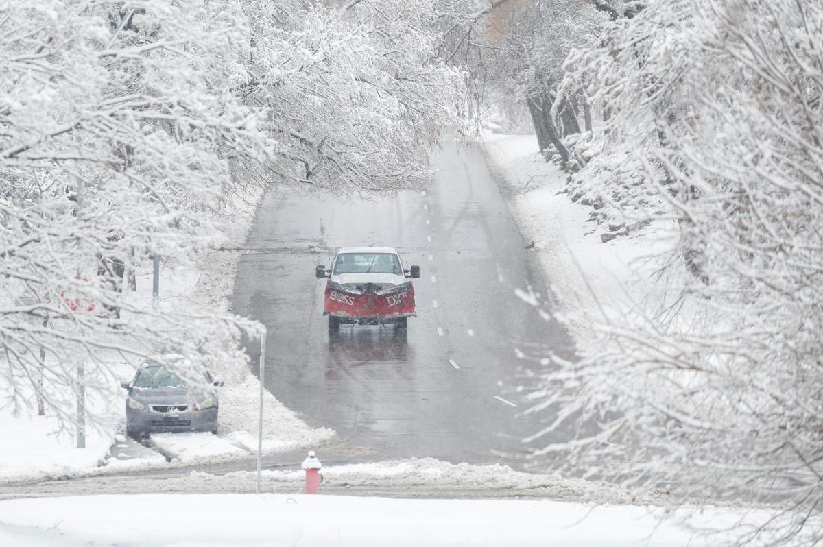 A snow plow makes its way along Gillham Road as heavy snow falls on Tuesday, Jan. 9, 2024, in Kansas City.