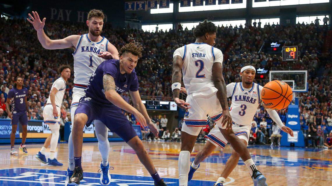 Kansas State Wildcats forward Coleman Hawkins (33) passes the ball away from Kansas Jayhawks center Hunter Dickinson (1) and guard A.J. Storr (2) during the first half at Allen Fieldhouse on Jan. 18, 2025.