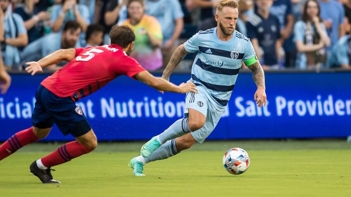 Sporting Kansas City forward Johnny Russell (right) attempts to maneuver around FC Dallas midfielder Facundo Quignon.