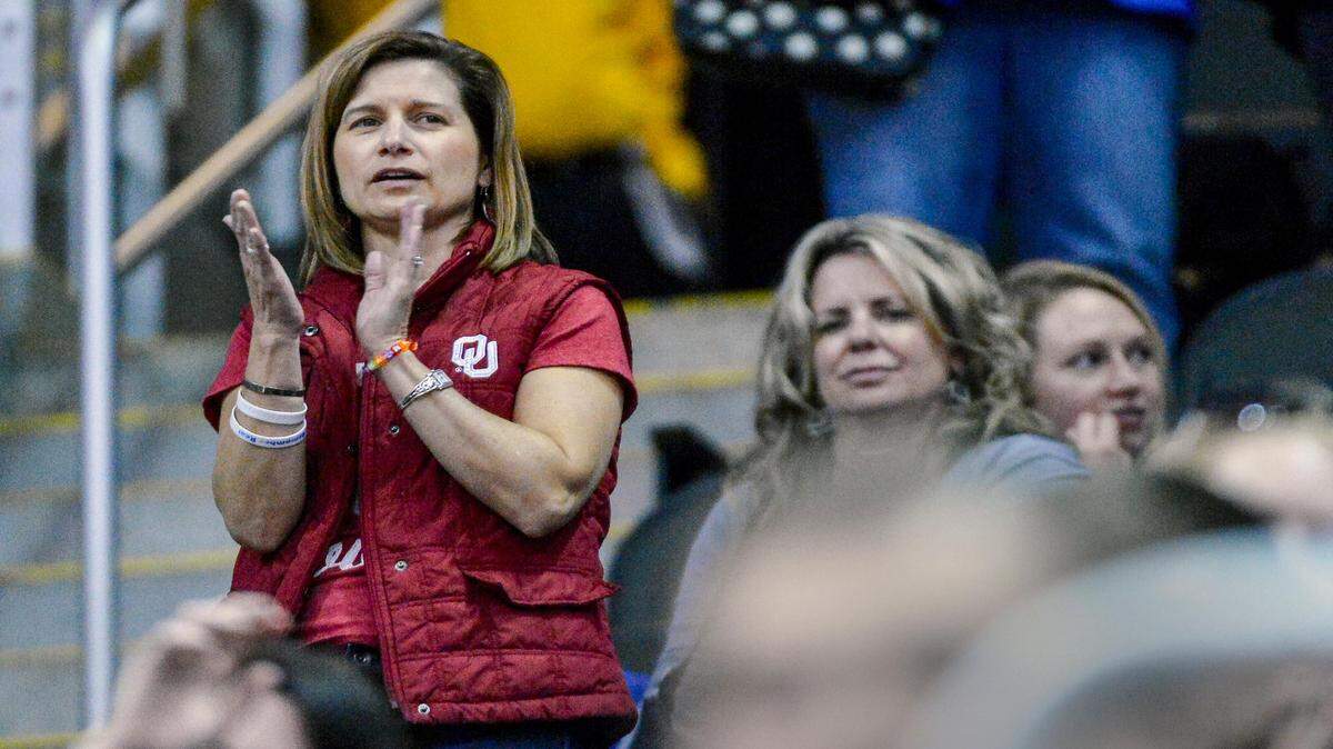 Mindy Corporon claps during the halftime show of Thursday OU-Oklahoma State game during the Big 12 Tournament at the Sprint Center.  Corporon, a former Oklahoma cheerleader, lost her father, William Corporon, and her 14-year-old son, Reat Griffin, in the shootings last April at the Jewish Community Center in Overland Park.