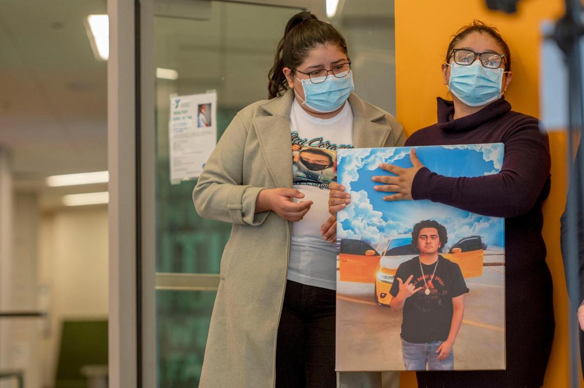 During the KC Common Good Fund press event Tuesday, Itati Becerra, left, and her mother Amapola Garcia, held a painting of her son, Carlos Ambriz-Garcia, who was shot and killed in front of his home last year. The KC Common Good Fund provides financial aid to cover funeral costs for victims of gun violence.