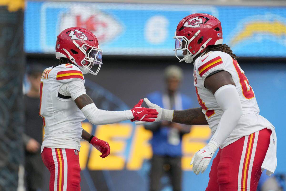 Kansas City Chiefs wide receiver Xavier Worthy (1) celebrates with linebacker Wanya Morris (64) after catching a 54-yard touchdown pass in the second quarter against the Los Angeles Chargers at SoFi Stadium.
