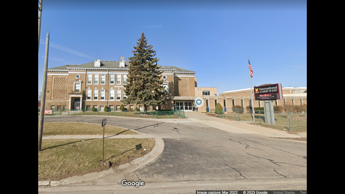 A mother shot another parent outside a school in Flint, Michigan, while picking up her child, officials say.