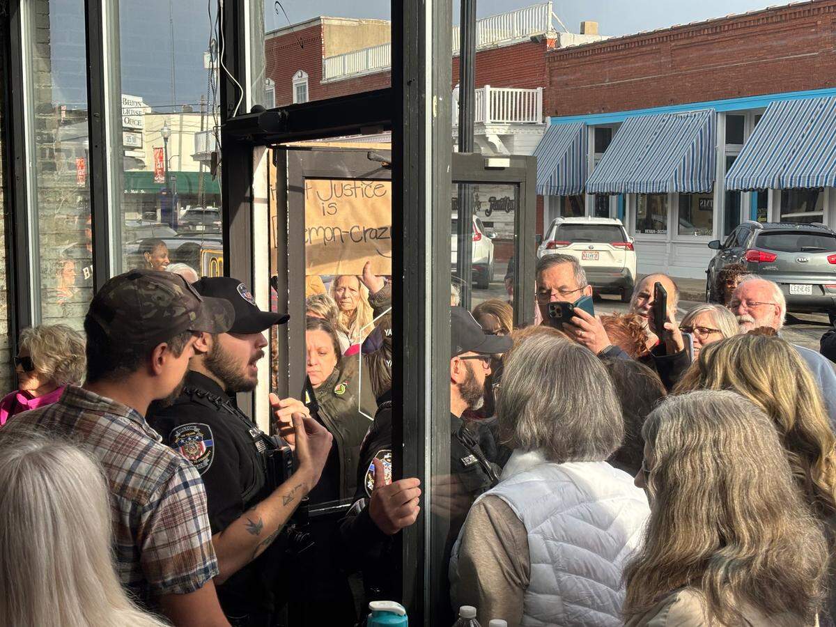 During a town hall with Rep. Mark Alford, police officers had a brief confrontation with the crowd outside as they attempted to close the door.