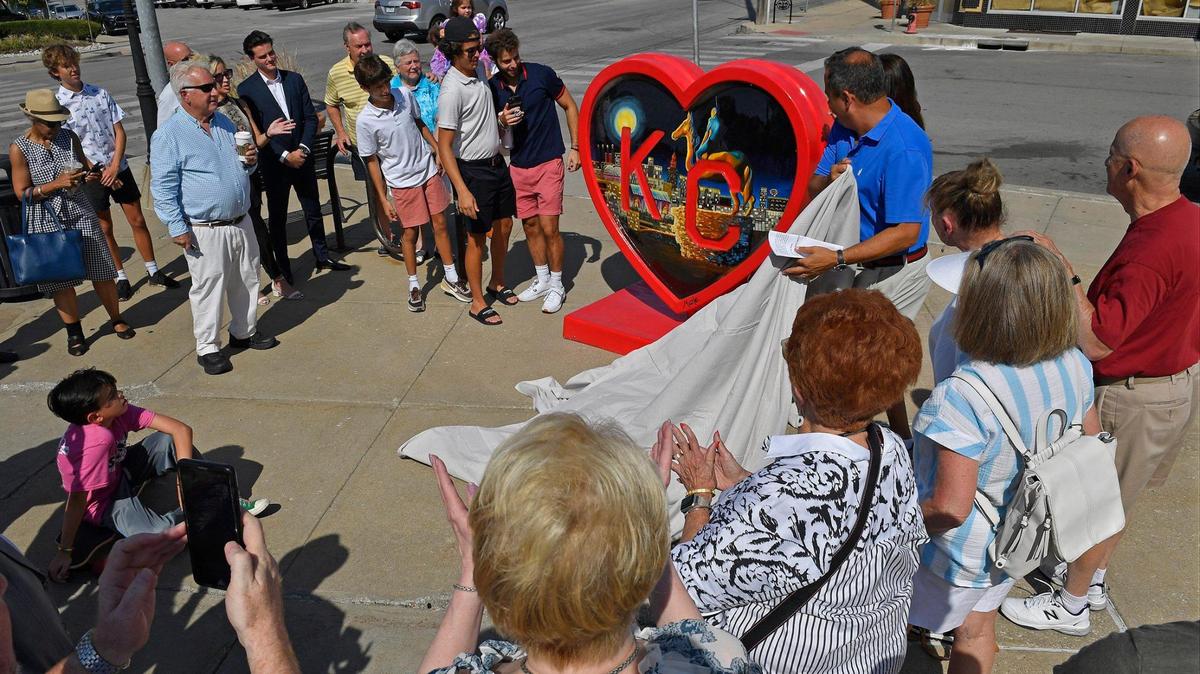 With the help of his family, Brookside property owner Joe Zwillenberg, right, unveiled “The Heart of Kansas City” during a ceremony Friday in Brookside. “This one just kept going up and up and up (in price) and I just didn’t care because I wanted this specific one for Brookside,” he said about the recent purchase at auction. “I just think it’s bright, it’s beautiful and it shows the heart of Kansas City, which is perseverance and good things will happen if you work hard. ”Marla Storey, the local artist who painted the heart said her painting was inspired by Kansas City’s skyline after the Chiefs won the Super Bowl in 2020. “It was just neat how everybody seemed to come together then, so I’m hoping people can get back to that,” Storey said. You can see the sculpture on the patio north of Starbucks, where it will be visible from 63rd Street, Brookside Plaza and for pedestrians on the Trolley Track Trail.