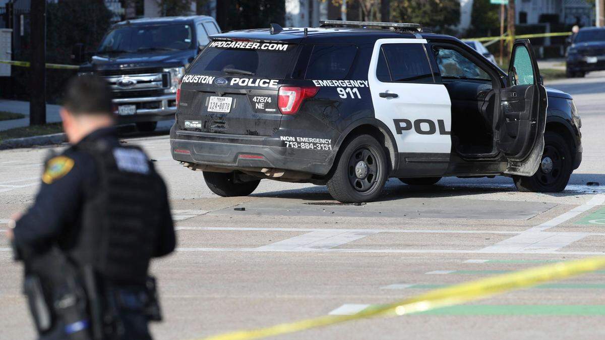 Authorities investigate the scene of a shooting Thursday in Houston. Authorities say a police chase in Houston ended with a shootout that wounded three officers.