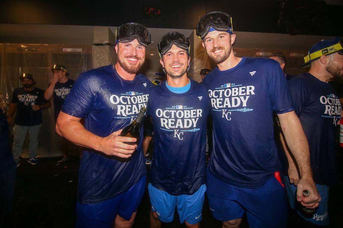 Kansas City Royals right fielder Hunter Renfroe (16) and second baseman Adam Frazier (26) and pitcher Chris Stratton (35) celebrate after clinching a wild card playoff birth after a game against the Atlanta Braves at Truist Park.