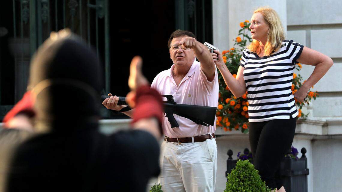 Armed homeowners Mark T. and Patricia N. McCloskey stand in front their house as they confront Black Lives Matter protesters on June 28, 2020, in St. Louis.
