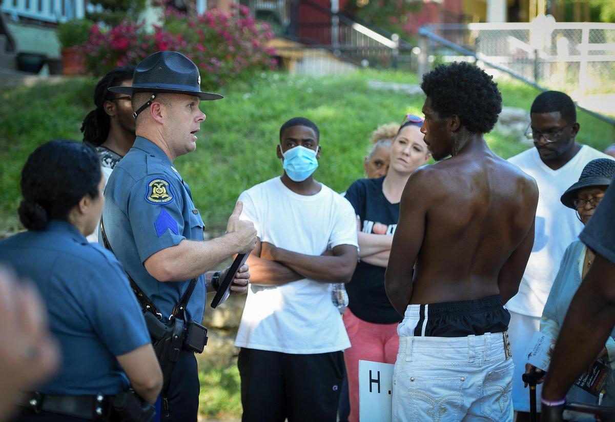 Missouri Highway Patrol spokesman, Sgt. Andy Bell, talked to bystanders including Troy Robertson, (center), who were upset after a Kansas City police officer shot and killed a man suspected of carjacking in the 2300 block of Lister Avenue on Saturday afternoon. Bell said incident started when an armed carjacking was reported near the 2300 block of Topping Avenue around 1:30 p.m. Saturday. Bell said the suspect “presented” a handgun when he was shot by the officer, which he explains to the bystanders. The Missouri Highway Patrol has been asked to investigate the shooting.