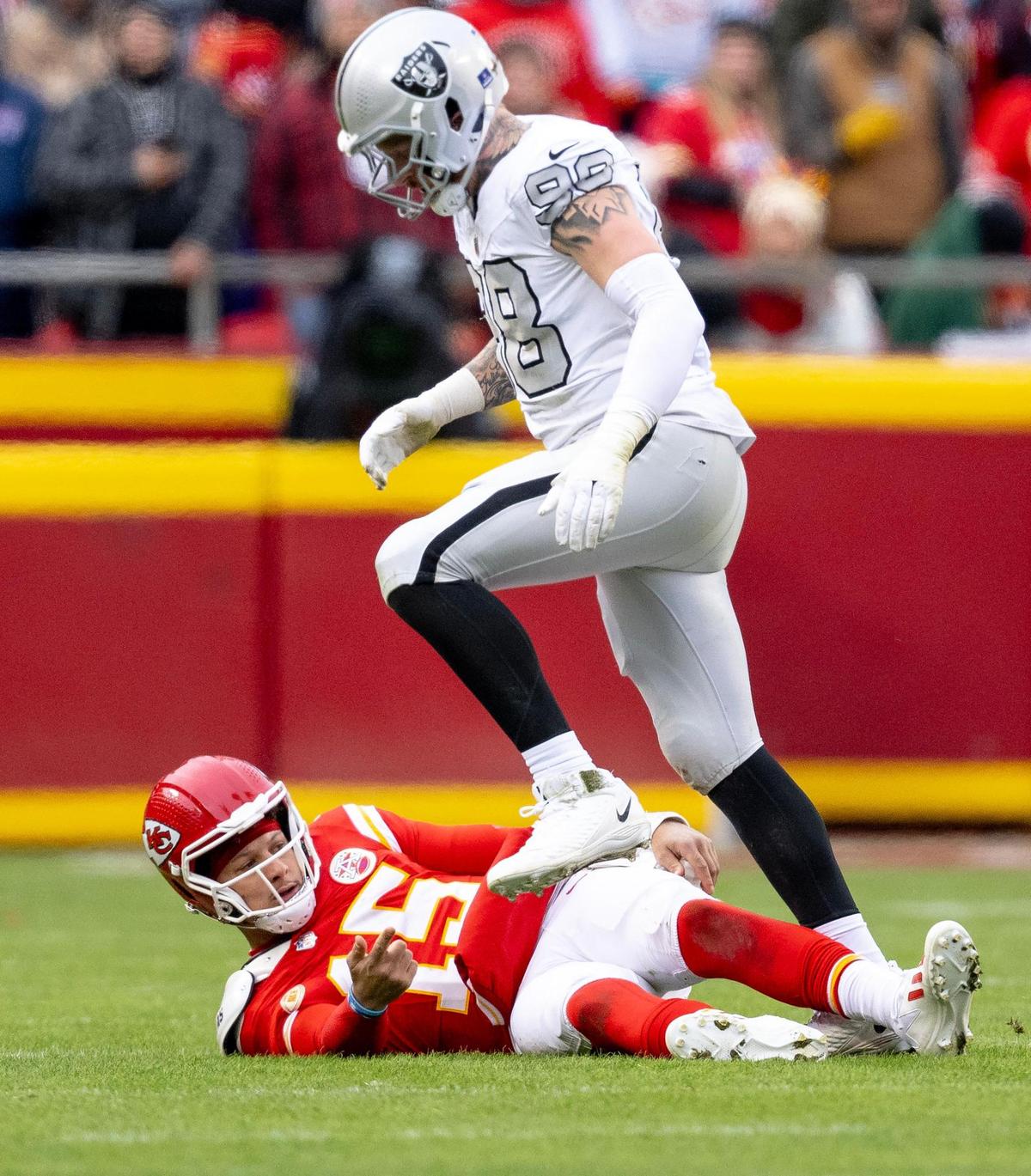 Las Vegas Raiders defensive end Maxx Crosby (98) steps over Kansas City Chiefs quarterback Patrick Mahomes (15) during an NFL football game on Monday, Dec. 25, 2023, at Arrowhead Stadium at GEHA Field in Kansas City.