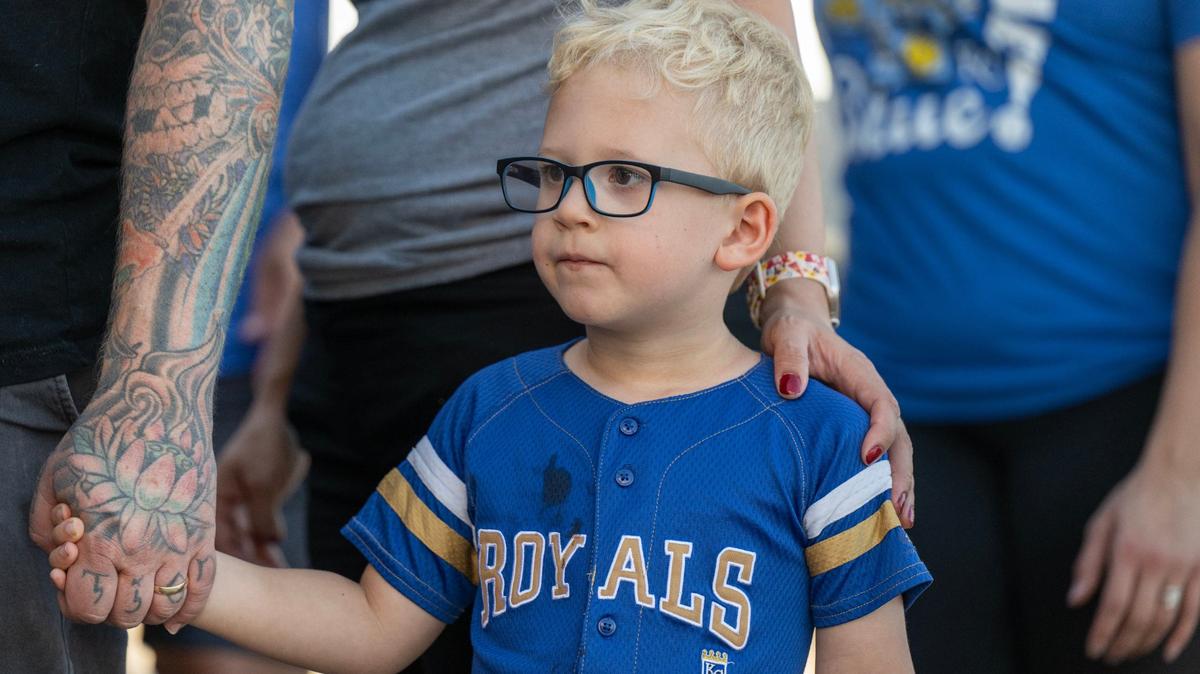Royals fan Jude McKenny, 4, holds hands with his father, Timm McKenny of Kansas City, as they wait to get autographs from Royals players during Bring Out the Blue, a tailgating event at the Price Chopper in Lee’s Summit on Monday, Sept. 30, 2024. The event was held ahead of the Royals AL Wild Card game on Tuesday against the Baltimore Orioles.