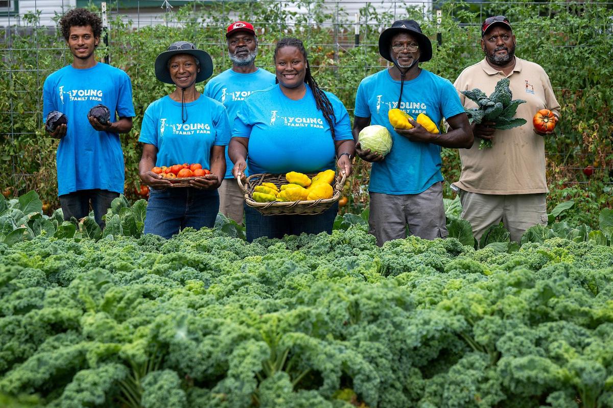 Members of the Young family, including from left, Stacey Welch Jr., Yolanda Young, Arthur Moss, Alana Henry, Stacey Welch Sr., and Alan Young, work on the Young family’s urban farm in Kansas City, owned by Alan and Yolanda Young.