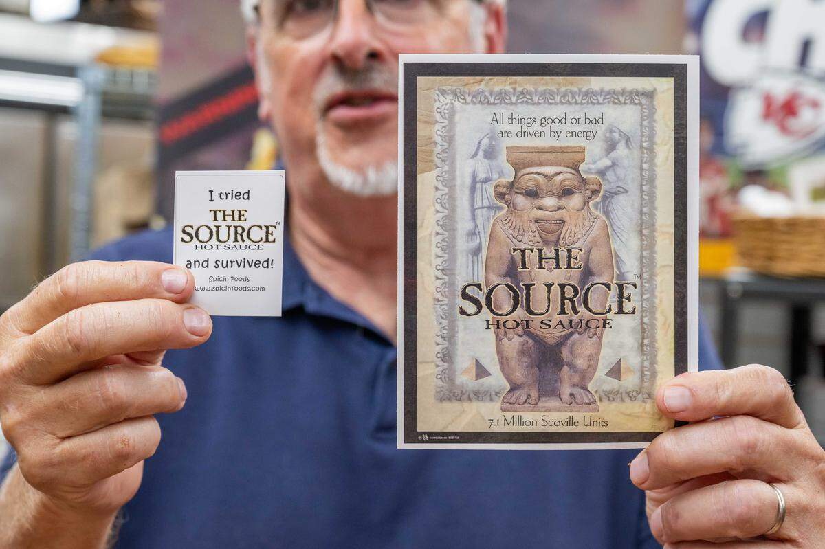 Star producer Randy Mason holds up a certificate for eating The Source, a hot sauce measured at 7.1 million Scovilles, at the Spicin Foods warehouse on Southwest Boulevard, on October 2, 2025, in Kansas City. Mason had to sign a waver before trying the hot sauce.