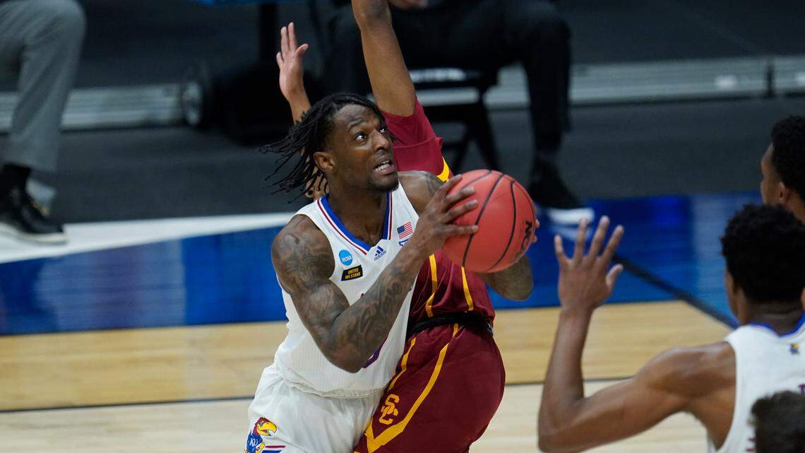 Kansas guard Marcus Garrett (0) tries to shoot around a USC defender during the first half of a men’s college basketball game in the second round of the NCAA tournament at Hinkle Fieldhouse in Indianapolis, Monday, March 22, 2021. (AP Photo/Paul Sancya)