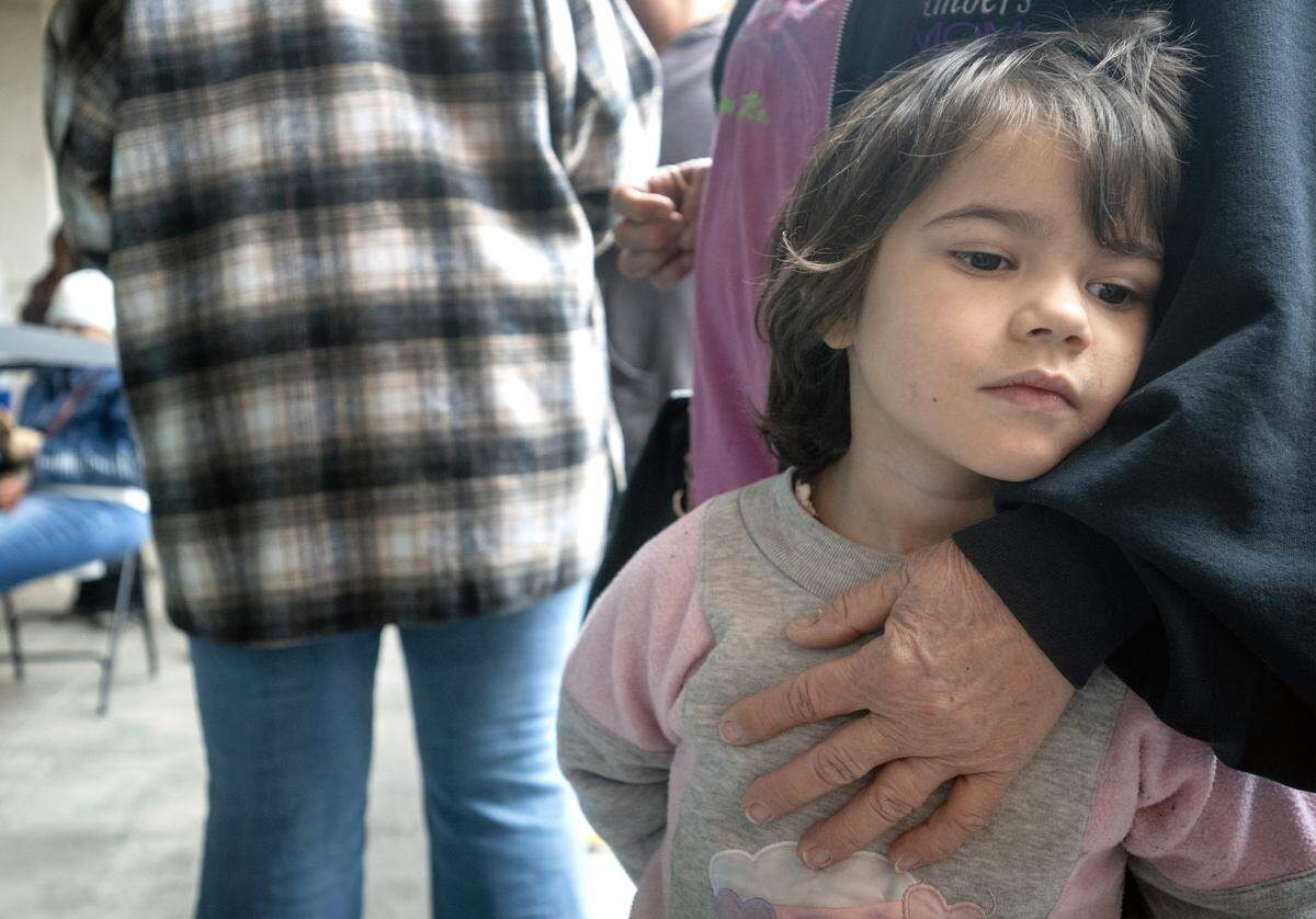 Four-year-old Zephy Moody clings to her grandmother, Debbie Moody, 66, of Lee’s Summit, as they wait in line for Harvester’s monthly food distribution at Jackson County Public Health in Lee’s Summit on Wednesday, November 19, 2025. Debbie Moody said she was picking up groceries to help feed the eight people in her household.