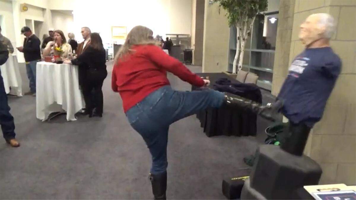 An unidentified woman kicks an effigy of President Joe Biden at the Johnson County Republican Party's "A Grand Ol' Party" March 8, 2024.