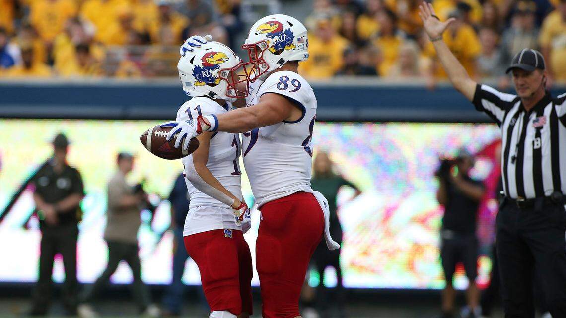 Kansas wide receiver Luke Grimm, left, and tight end Mason Fairchild celebrate after a touchdown against West Virginia on Saturday in Morgantown, W.Va.
