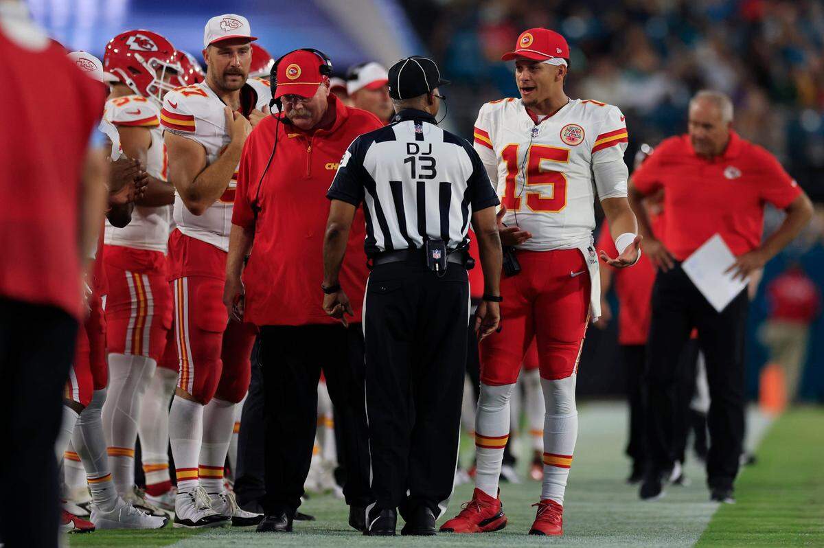 Kansas City Chiefs quarterback Patrick Mahomes (15) talks with a referee as head coach Andy Reid and tight end Travis Kelce (87) are on the sideline during the second quarter of a preseason NFL football game Saturday, Aug. 10, 2024 at EverBank Stadium in Jacksonville.
