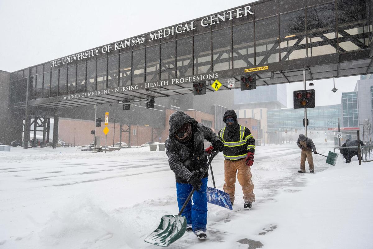 Maintenance workers shovel snow outside the University of Kansas Medical Center on Sunday, Jan. 5, 2025.