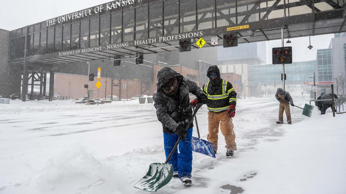 Maintenance workers shovel snow outside the University of Kansas Medical Center on Sunday, Jan. 5, 2025.