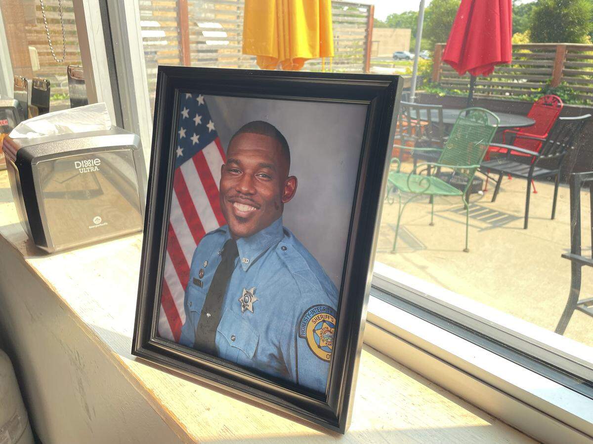 A photo of of Wyandotte County sheriff's deputy Elijah Ming is displayed near table 71 at Gus's Fried Chicken in Kansas City, Kansas. Ming, who was killed in the line of duty while responding to a call, was a regular at the restaurant.