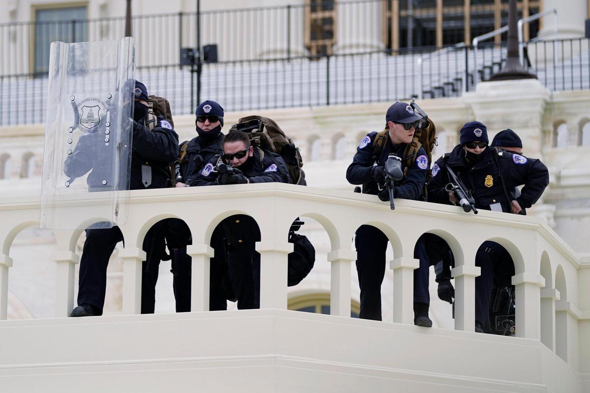 Police keep a watch on demonstrators who tried to break through a police barrier, Wednesday, Jan. 6, 2021, at the Capitol in Washington. As Congress prepares to affirm President-elect Joe Biden’s victory, thousands of people have gathered to show their support for President Donald Trump and his claims of election fraud. (AP Photo/Julio Cortez)