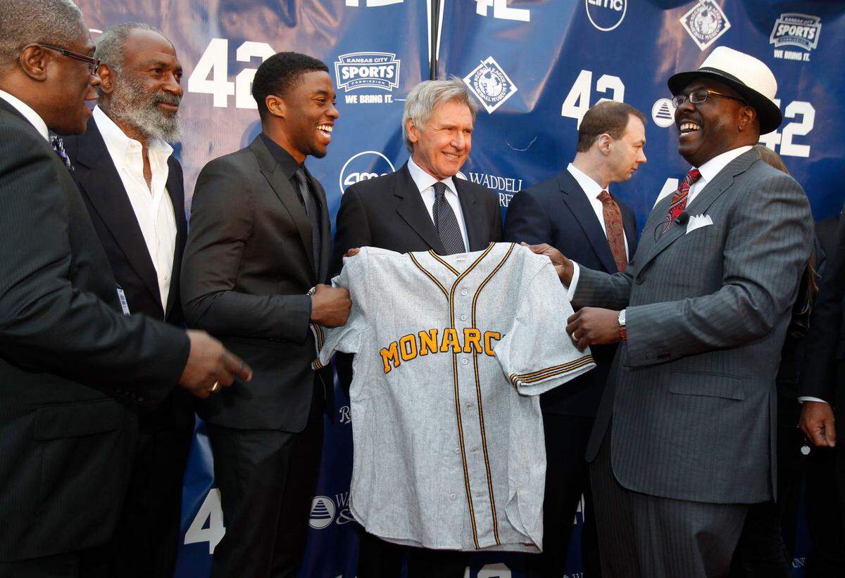 Chadwick Boseman starred as Jackie Robinson in the 2013 biopic “42,” which premiered at the AMC Barrywoods in Kansas City. On the red carpet, Boseman and co-star Harrison Ford presented the jersey Boseman wore in the film to Bob Kendrick, right, president of the Negro Leagues Baseball Museum. Looking on were then-Kansas City Mayor Sly James, from left, and David Robinson, Jackie Robinson’s son.