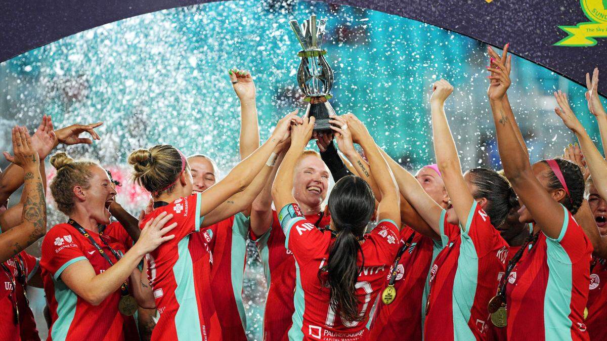 Kansas City Current players celebrate with the trophy after beating Atletico de Madrid to win The Women’s Cup at CPKC Stadium on Aug. 17, 2024.