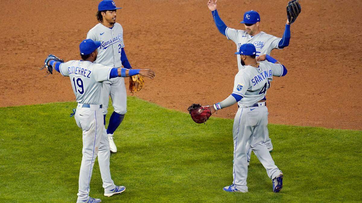 Kansas City Royals players Kelvin Gutierrez (19), Michael A. Taylor (2), Carlos Santana (41) and Whit Merrifield celebrate a win over the Minnesota Twins in a baseball game, Friday, May 28, 2021, in Minneapolis. (AP Photo/Jim Mone)
