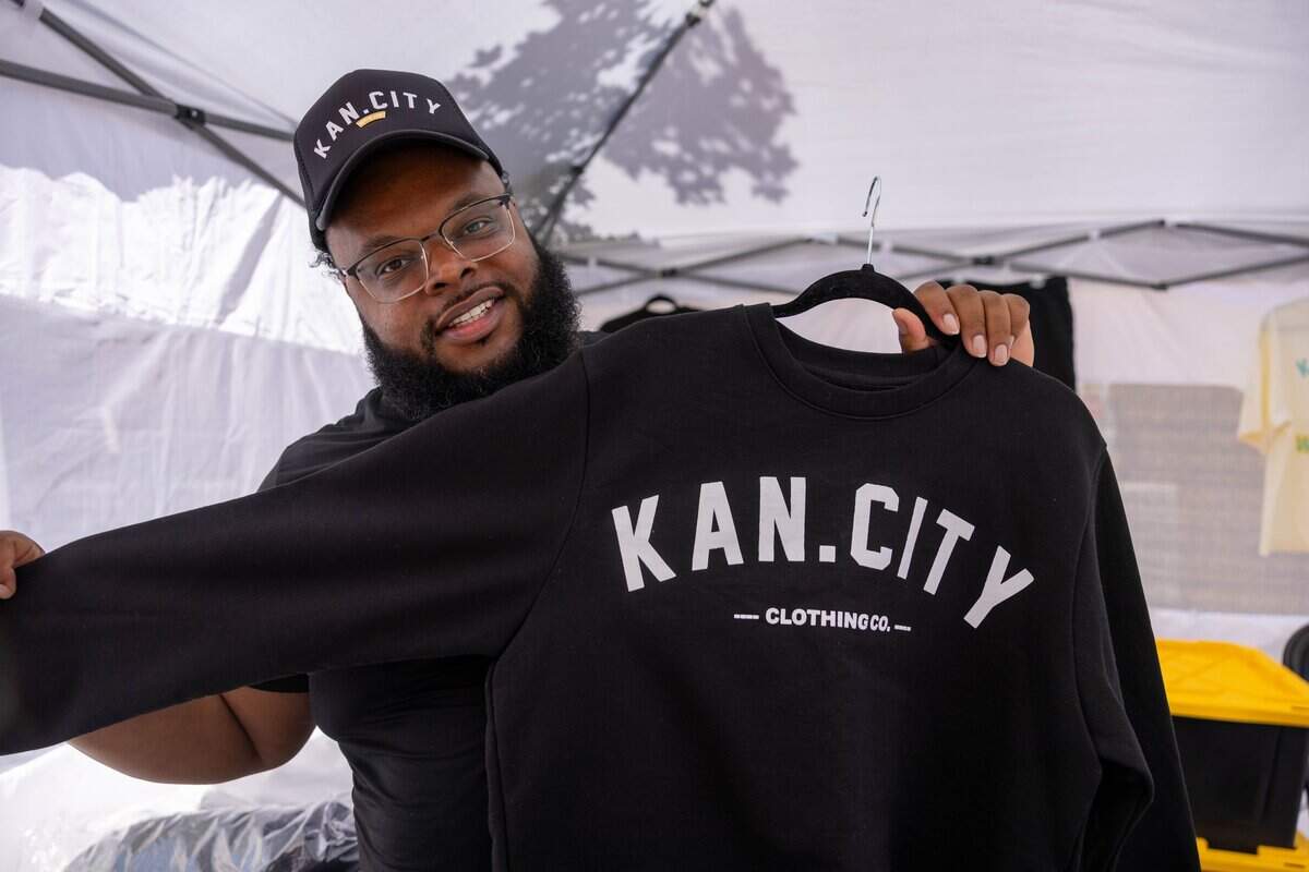 Caymen Depriest, Owner of Kan. City Clothing Co. shows off their crew neck during JuneteenthKC 15th Annual Heritage Festival at E 18th Street on Saturday, June 20, 2026. “I just love lounge wear and I'm a lounge wear person,” quoted Depriest. “Jeans just aint my style.”