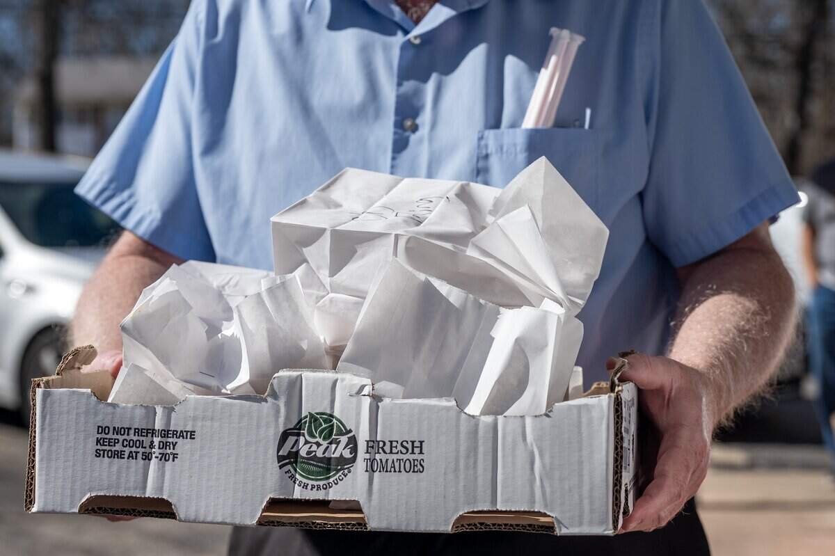 A customer carries a cardboard box filled with orders at Christy's Tasty Queen on Wednesday, Feb. 18, 2026, in Kansas City, Kansas. Customers gathered for the restaurant's final day under its founding owners.