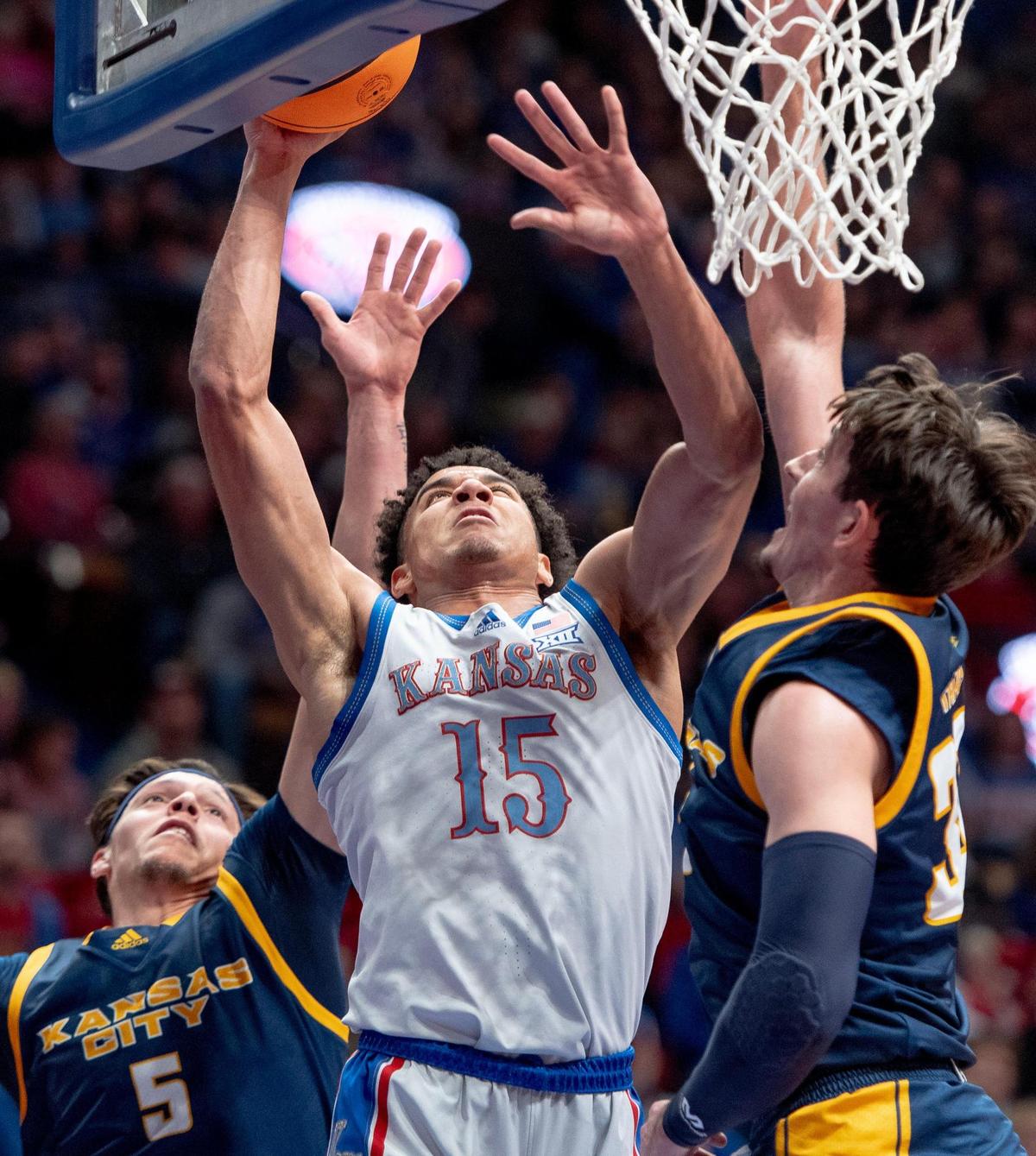 Kansas Jayhawks guard Kevin McCullar Jr. (15) shoots a layup as KC Roos guard Cameron Faas (30) defends during an NCAA basketball game on Tuesday, Dec. 5, 2023, in Lawrence, Kan.