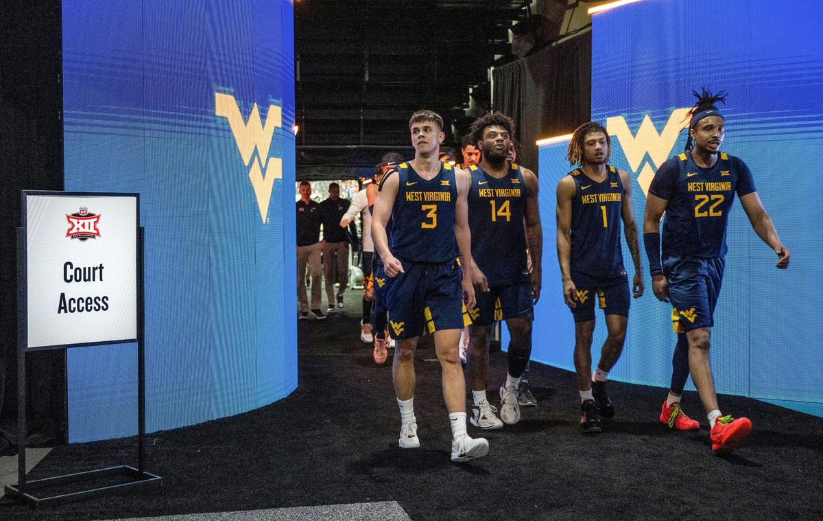 Digital displays with team logos light the way on and off the court for the teams playing in the Big 12 basketball tournament at T-Mobile Center. Team members of the West Virginia Mountaineers head to the locker room for halftime during their Tuesday game with the Cincinnati Bearcats.