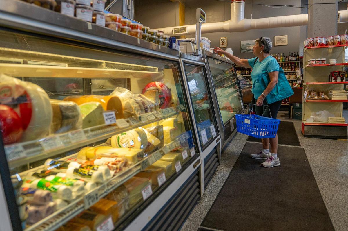 A shopper picks up fresh mozzarella from Carollo’s Grocery & Deli in the City Market.
