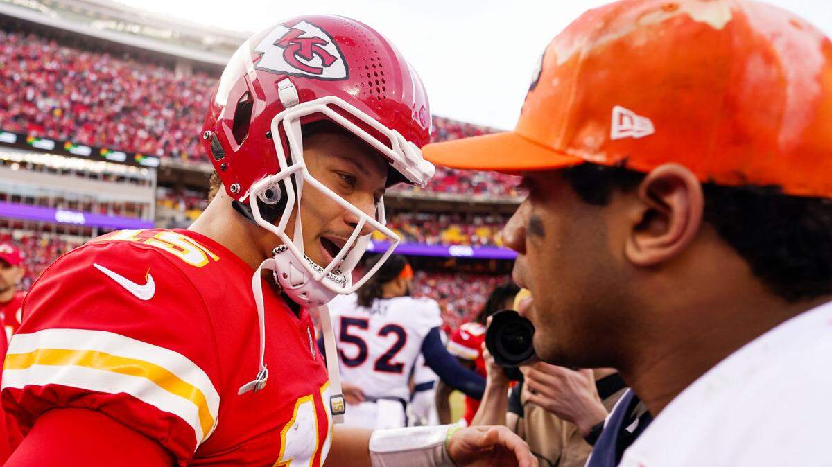 Kansas City Chiefs quarterback Patrick Mahomes (15) talks with Denver Broncos quarterback Russell Wilson (3) after a game at GEHA Field at Arrowhead Stadium on Jan. 1, 2023.