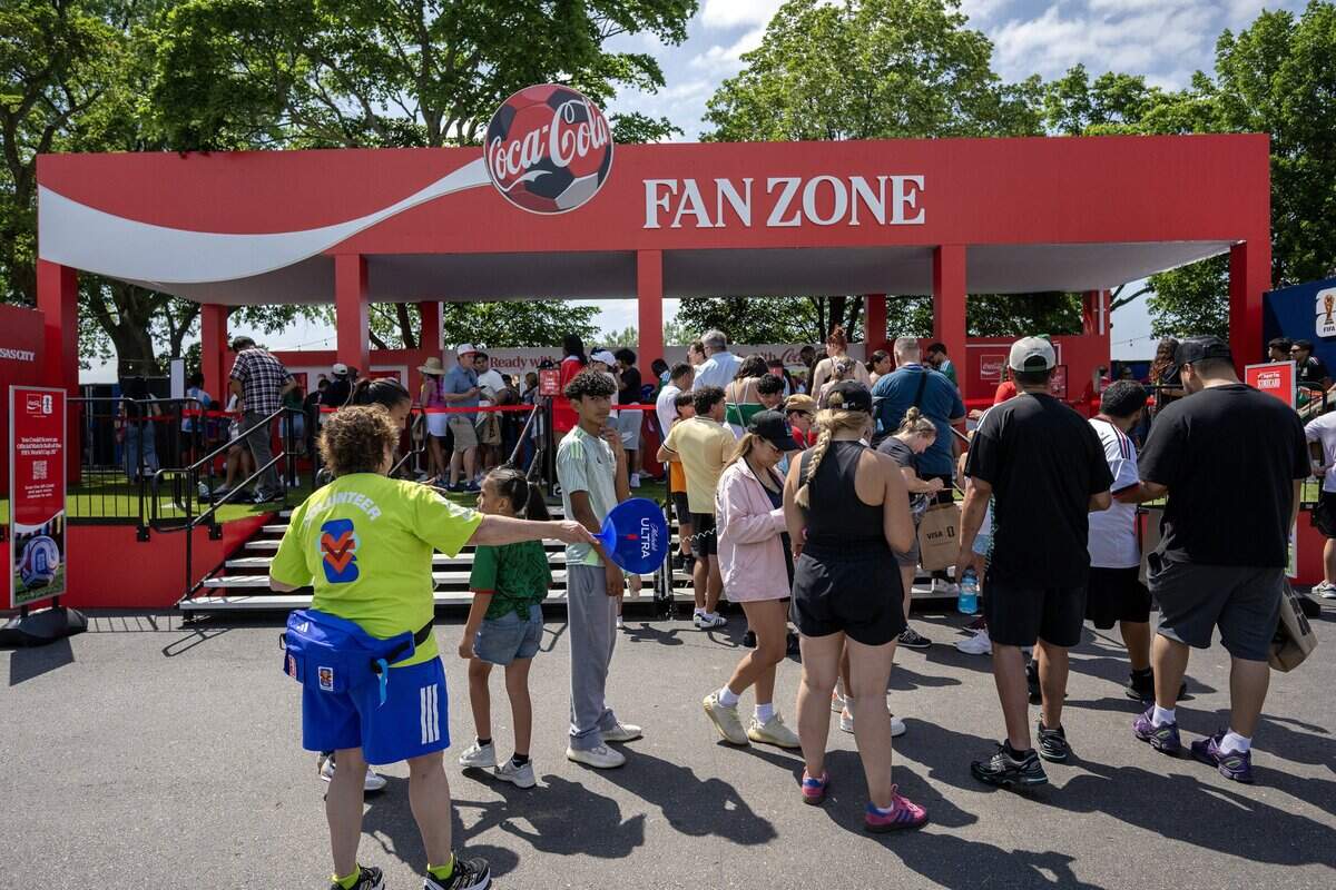 Fans stand in line take take photos of the Coca-Cola fan zone while attending the FIFA Fan Festival on Thursday, June 11, 2026, in Kansas City.