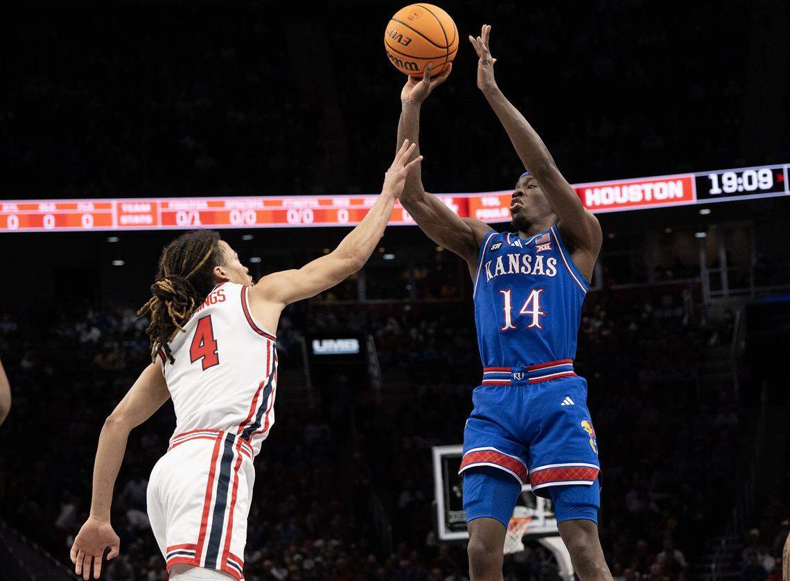 Kansas Jayhawks guard Melvin Council Jr. (14) gets a shot off as Houston Cougars guard Kingston Flemings (4) defends in the first half at the Big 12 Men's Basketball Tournament at T-Mobile Center on Friday, March 13, 2026, in Kansas City.