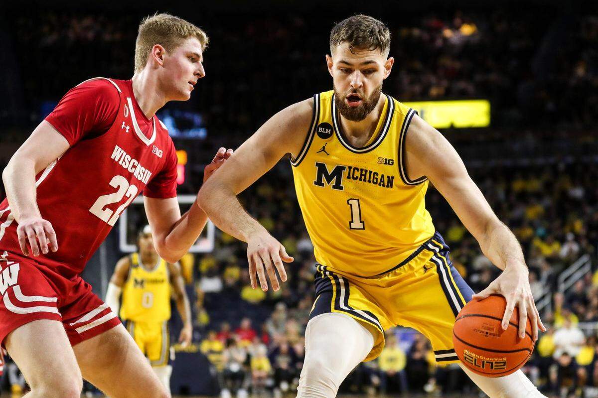 Michigan center Hunter Dickinson dribbles against Wisconsin forward Steven Crowl during the first half on Sunday, Feb. 26, 2023, at Crisler Center. Dickinson is a top NCAA transfer portal target for Kentucky.