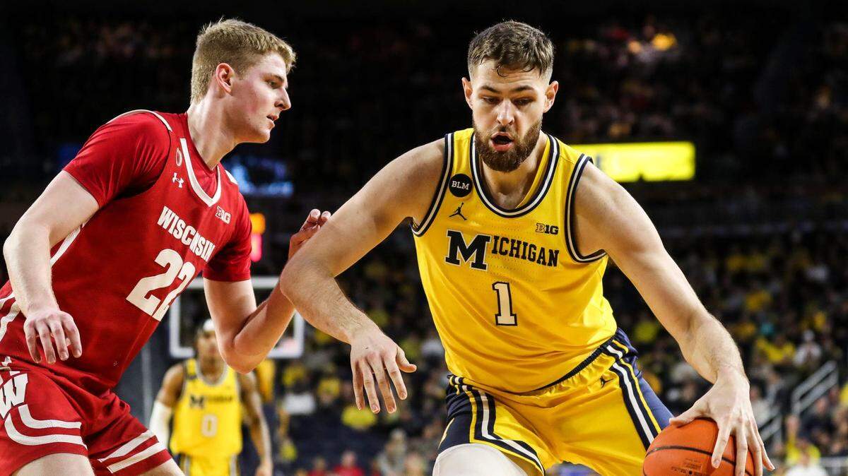Michigan center Hunter Dickinson dribbles against Wisconsin forward Steven Crowl during the first half on Sunday, Feb. 26, 2023, at Crisler Center.