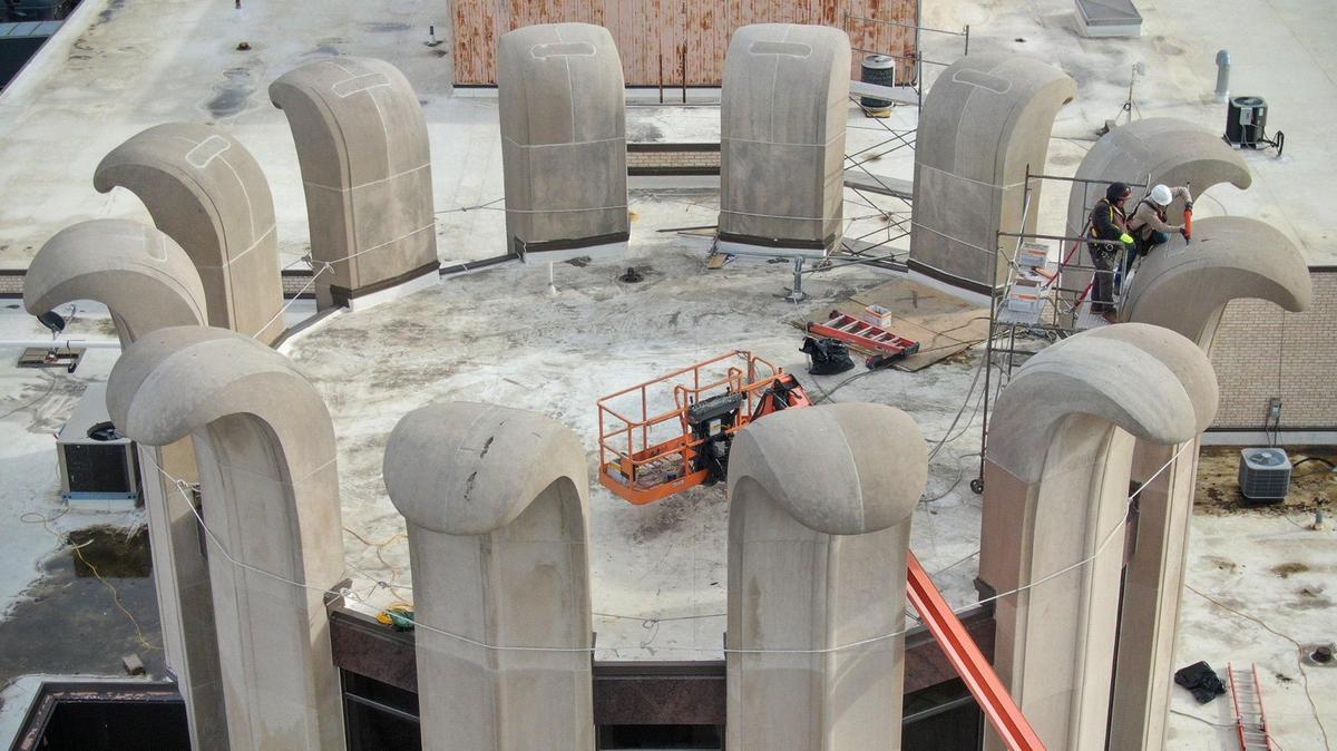 A crew from MTS Contracting, Inc., of North Kansas City, does renovation work the curved concrete pillars on the building at 8101 Lenexa Drive in Lenexa on Dec. 19.
