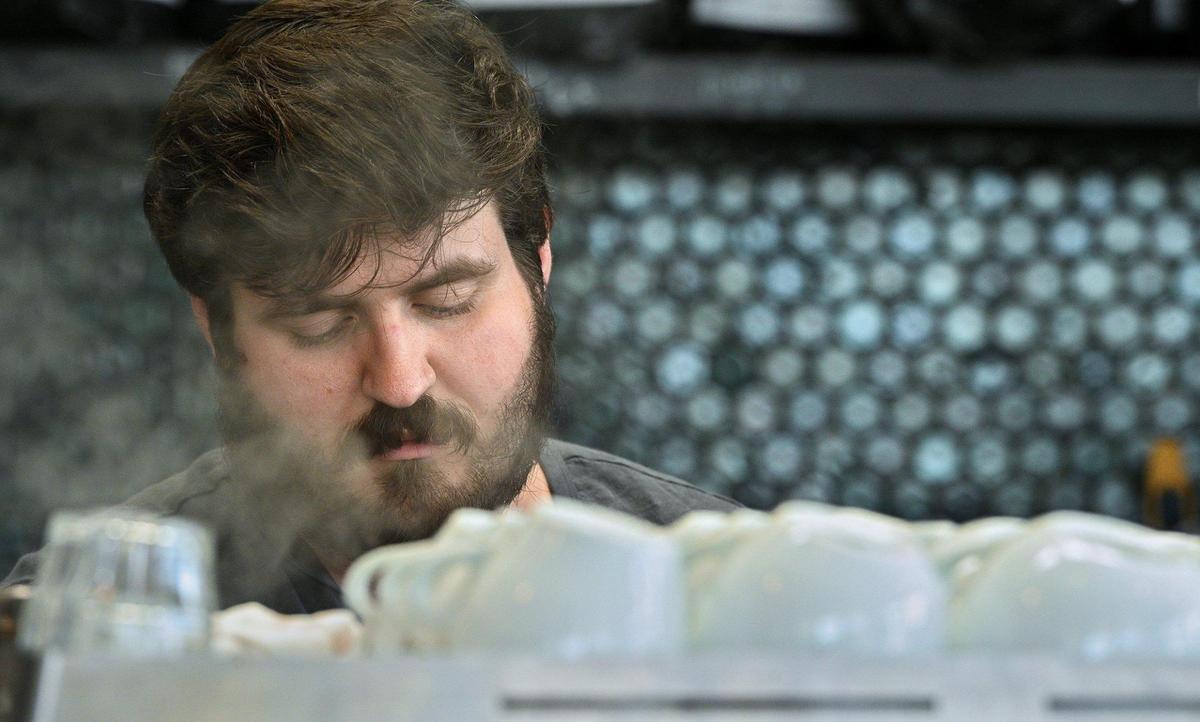 Steam rises around Edward Griffin while they make drinks at Messenger Coffee. Griffin has competed in latte art events in  Tulsa, Portland, Reno, Seattle and Baltimore.