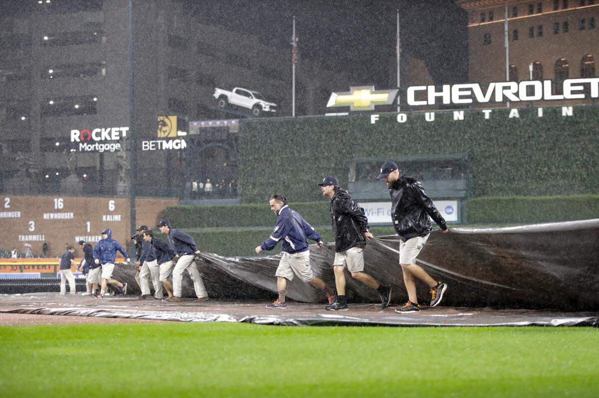 The Detroit Tigers grounds crew pulls a tarp over the field during the fifth inning of Wednesday evening’s suspended game at Comerica Park.