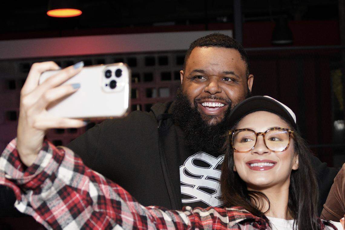 Glenn Robinson, creator of Hood Dude Food Reviews takes photo with a fan at Vine Street Brewing Co.