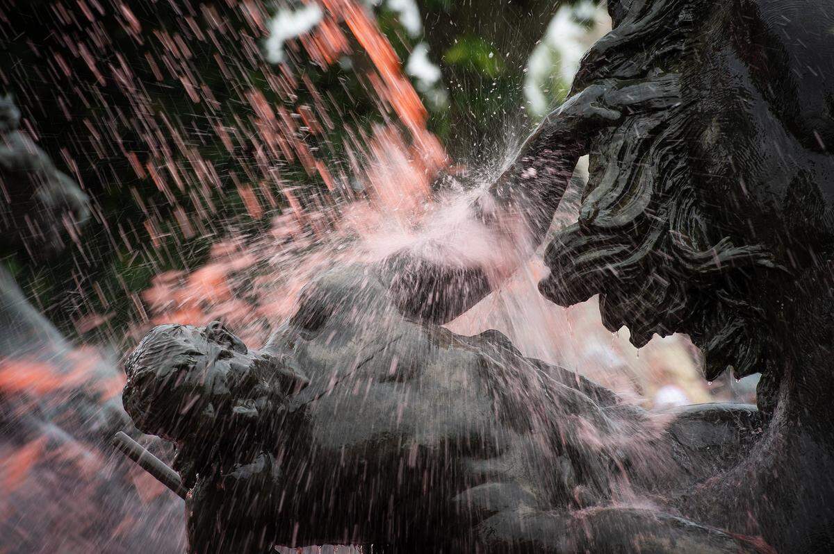 A sculpture in the fountain at Mill Creek Park is splashed with water dyed red for the kick off of Red Friday celebrations on Friday, Sept. 5, 2024, in Kansas City.