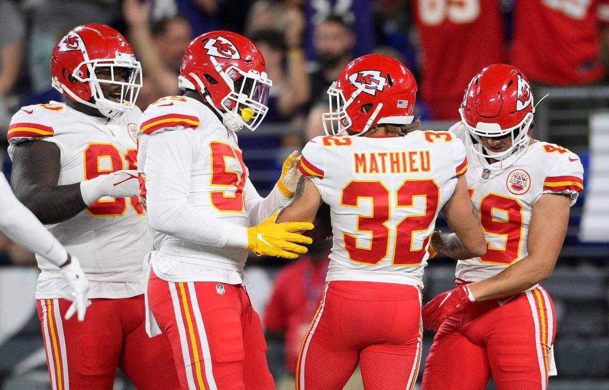 Chiefs defensive end Frank Clark, second from left, celebrates with safety Tyrann Mathieu and other teammates after Mathieu’s pick-six against the Baltimore Ravens this past season.
