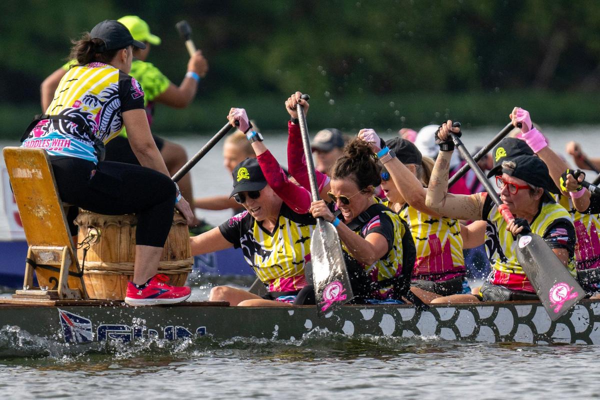 Crew members from Paddles with a Purpose paddle in a qualifying race during the KC Dragon Boat Festival on Saturday, Sept. 28, 2024, at Shawnee Mission Park.