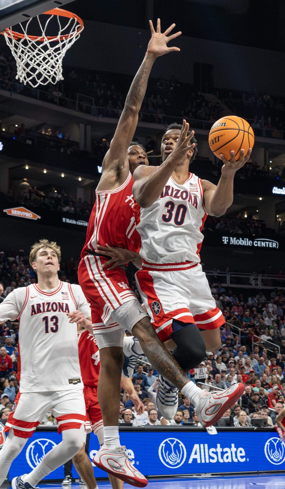 Arizona Wildcats forward Tobe Awaka (30) makes a layup over Houston Cougars forward Joseph Tugler (11) during the second half of the Big 12 Men's Basketball Tournament Championship game at T-Mobile Center on Saturday, March 14, 2026, in Kansas City.