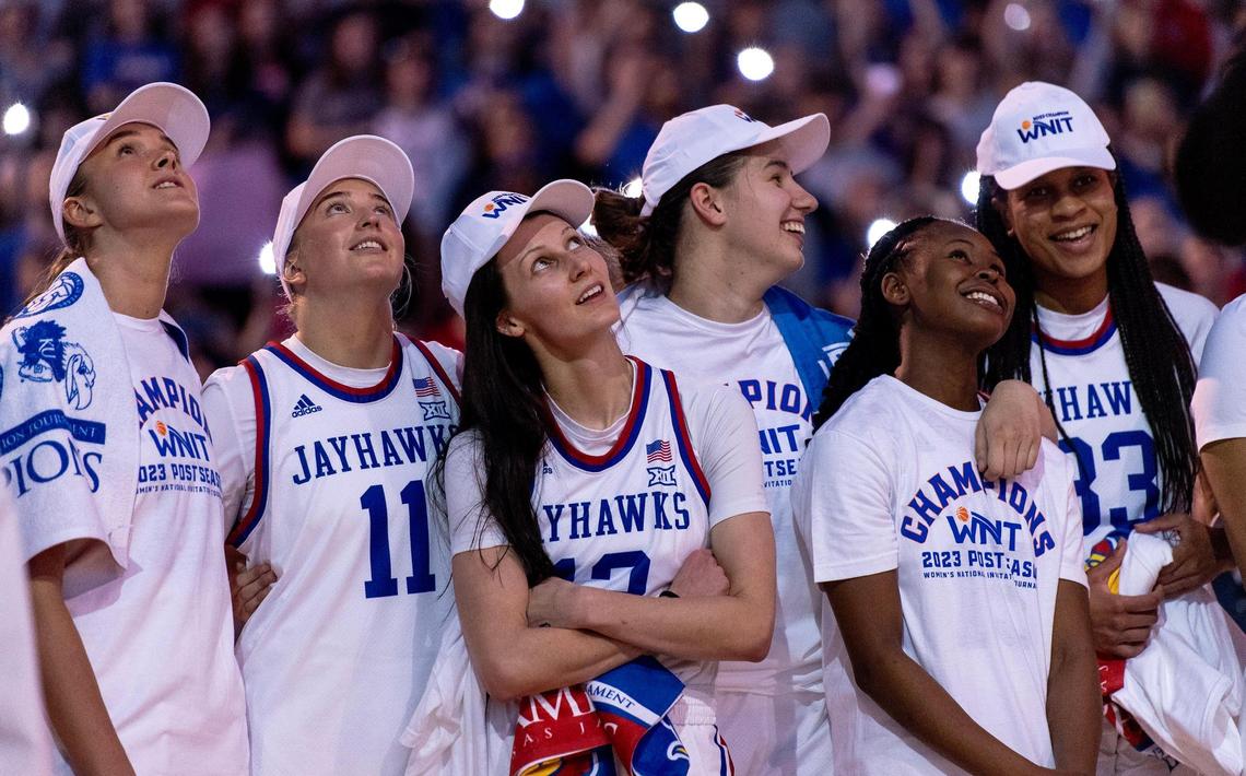 Kansas players watch a highlight reel of their WNIT tournament run after defeating Columbia 66-59 in an NCAA college basketball game in the final of the WNIT, Saturday, April 1, 2023, in Lawrence, Kan.